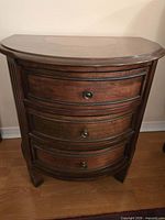 Front view of wooden demi-lune end table with three drawers