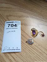 Overview of all three gold jewellery pieces: pendant-brooch, charm, single earring