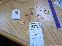 overview showing all gold items including pendant, chain, earrings, findings