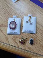 Group shot of the four 14K gold gemstone pendants