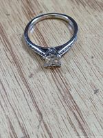 Ring front view showing princess center stone and pavé shoulders