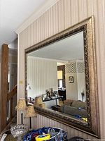 Full view of rectangular ornate gold mirror on wall
