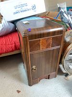 Full view of nightstand showing door, brass pull, inlay, rounded corners
