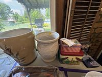 Planters and stack of tins on table