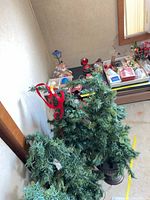 three potted artificial trees with lights and red ribbons