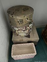 stack of hat boxes and pink wicker basket
