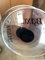 Front view of clear Baxon bass drum head showing logo and center dot