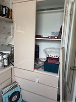 Full view of wardrobe showing sliding door, interior shelf and contents for scale
