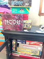 Stack of Encore, Scene It? 2, Trivial Pursuit Family Edition, Scattergories on cabinet