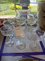 Nine clear stemmed coupe glasses grouped together