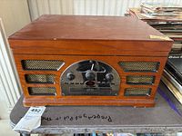 Front view of Crosley wood veneer turntable showing control panel and speaker grilles
