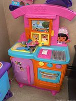 Full view of Dora the Explorer play kitchen with accessories on counter