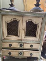 Front view of cabinet showing doors, drawers, color scheme, hardware, visible wear