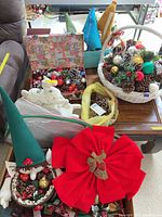 Overview of table with baskets of pine cones, ornaments, ceramic horse, bow