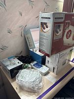 Lot overview showing boxed MyCareLink communicator, foot massager, nebulizer, tubing and accessories