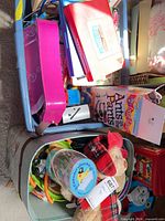 Tote containing board game, books, plush reindeer, toy colanders with contents