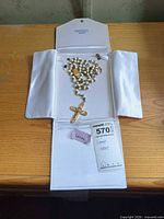 Rosary inside open white case showing overall layout