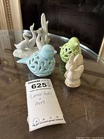 group shot of all six Lenox porcelain figurines on glass table