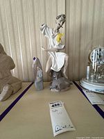 Seated Don Quixote Lladró figurine with smaller broken Madonna figure beside it