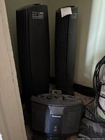 Two Ionic Breeze Quadra tower air purifiers and Holmes heater grouped together