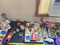 Overview of table with mixed ornaments, wreaths, gingerbread figurines and boxed items