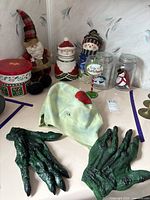 Overall lot showing mask, gloves, plush Santa, ceramic canisters, glasses and tins