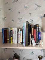 Shelf of mixed hardcover and paperback titles, front view