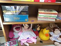 Bookshelf with board games, plush toys, doll and rubber duck