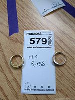Both rings displayed with lot tag showing 14K marking