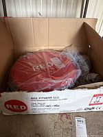 Open box showing red exercise step component inside plastic