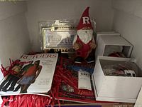 Shelf view showing magazine, license frame, gnome, boxed ornaments and pom-pom