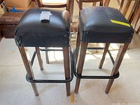 Front view of both bar stools showing seats, legs and footrests