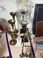 Overall lot showing brass candlesticks, hurricane candle holders, easel