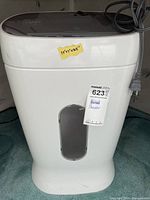 Front view of white Staples shredder showing bin window and power cord
