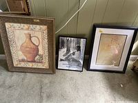 Group view of three framed prints on floor