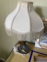 Full view of lamp with shade showing design and fringe