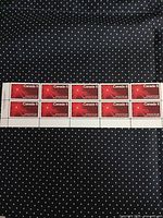 Full pane of 10 stamps on dark polka-dot background