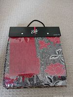 Front of Elite Textiles sample book showing carry handle and visible red floral swatch