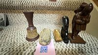 All items on stair: vase, two stones, black tiki carving, brown standing figure, pair horse bookends behind