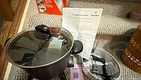 Wax melter pot with lid, instruction sheet, basket and accessories visible
