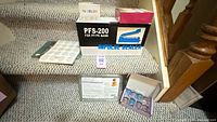 Overall lot showing PFS-200 box, mica pigment set box, soap base pack, items on stair