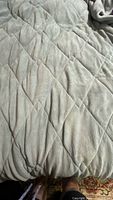 Close view of diamond quilted stitching on light gray microfiber blanket