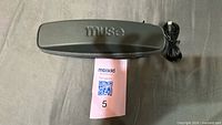 Closed Muse-branded hard case with coiled USB cable beside