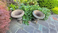 Two cast iron urns side by side on patio