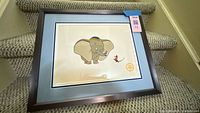 Framed Dumbo serigraph on staircase