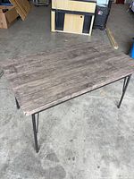 Full view of rectangular laminate table showing top and metal legs