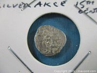 Obverse side of silver akçe coin in holder