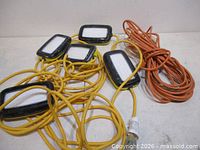 Overall view showing five-head LED work light string and coiled orange extension cord