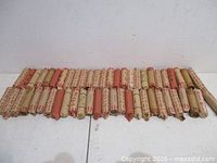 Front view of all 53 wrapped penny rolls lined in a row