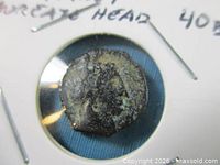 Obverse of coin displaying laureate head within holder window